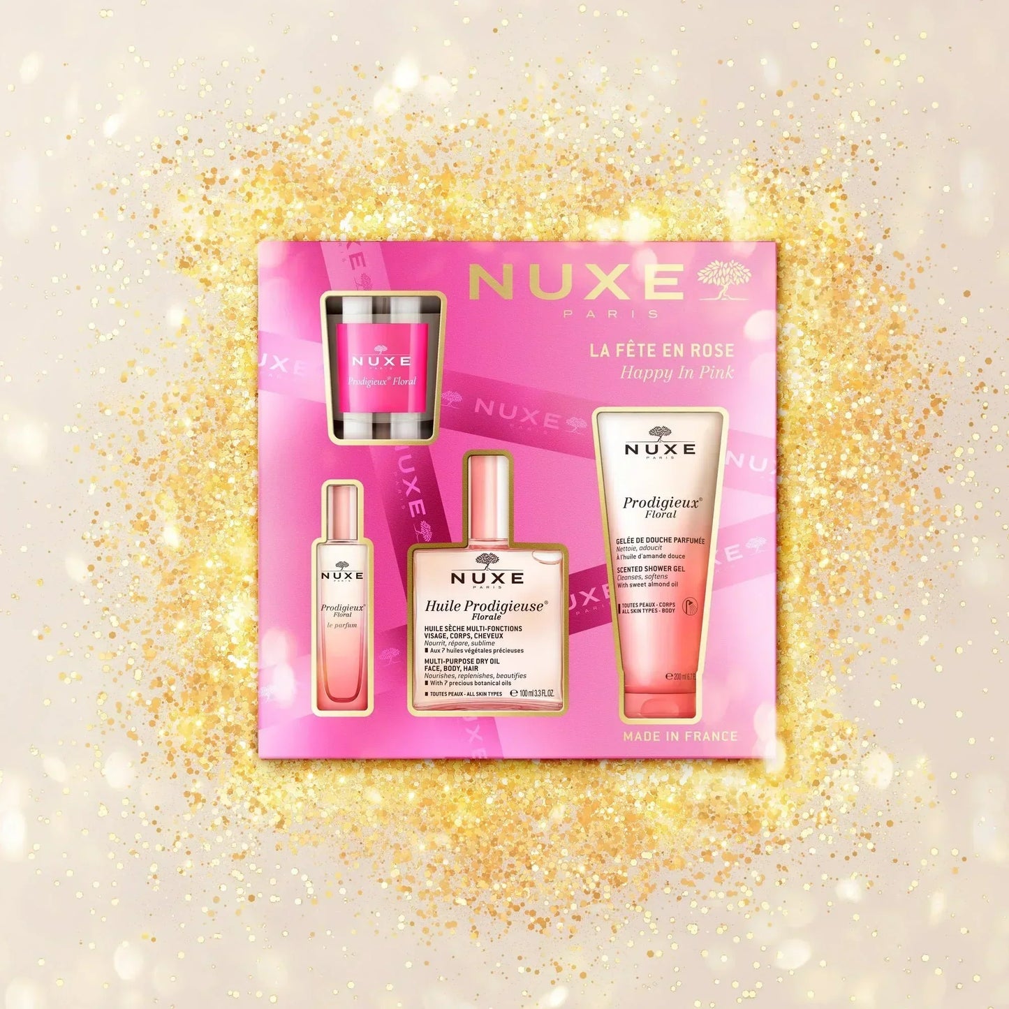 NUXE Happy in Pink gift set with skincare products on a gold glitter background at Goldfarmaci