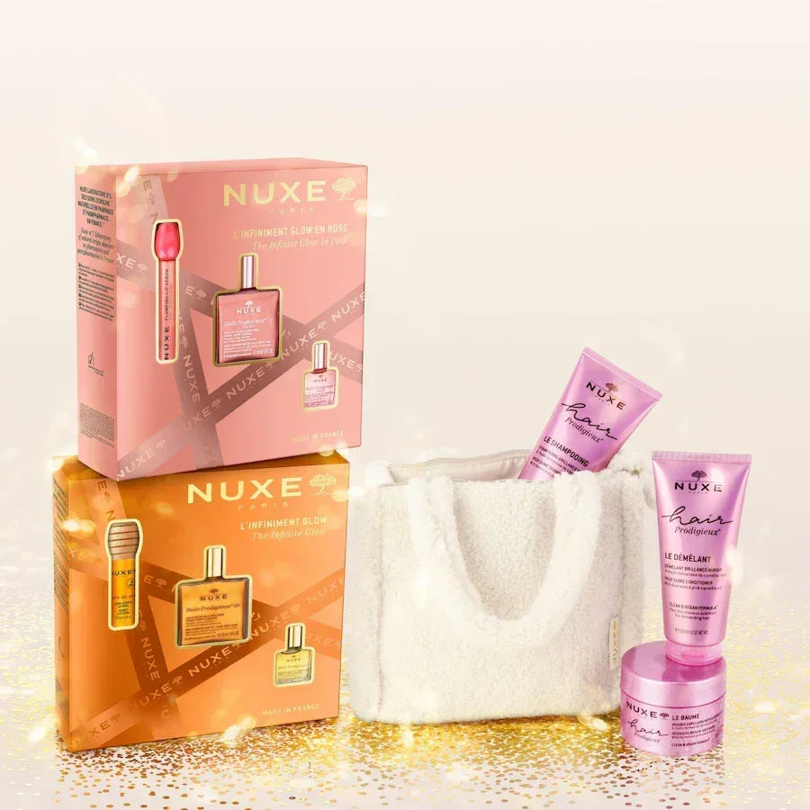 Nuxe luxury hair care set with pink and gold boxes, haircare products, and a white tote bag