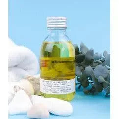 Clear bottle of nourishing oil for hair and skin with natural stones and green leaves
