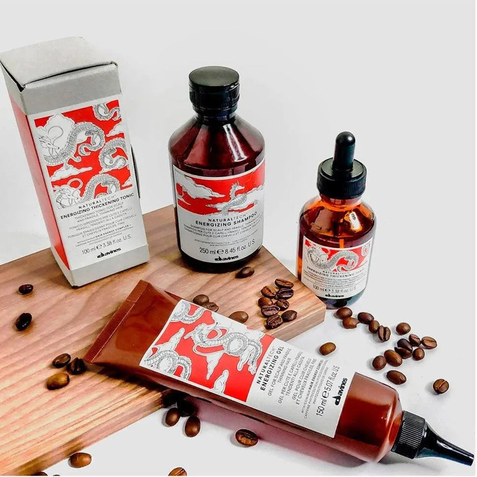 Energizing haircare set with shampoo, tonic, gel, and serum in amber bottles, coffee beans nearby