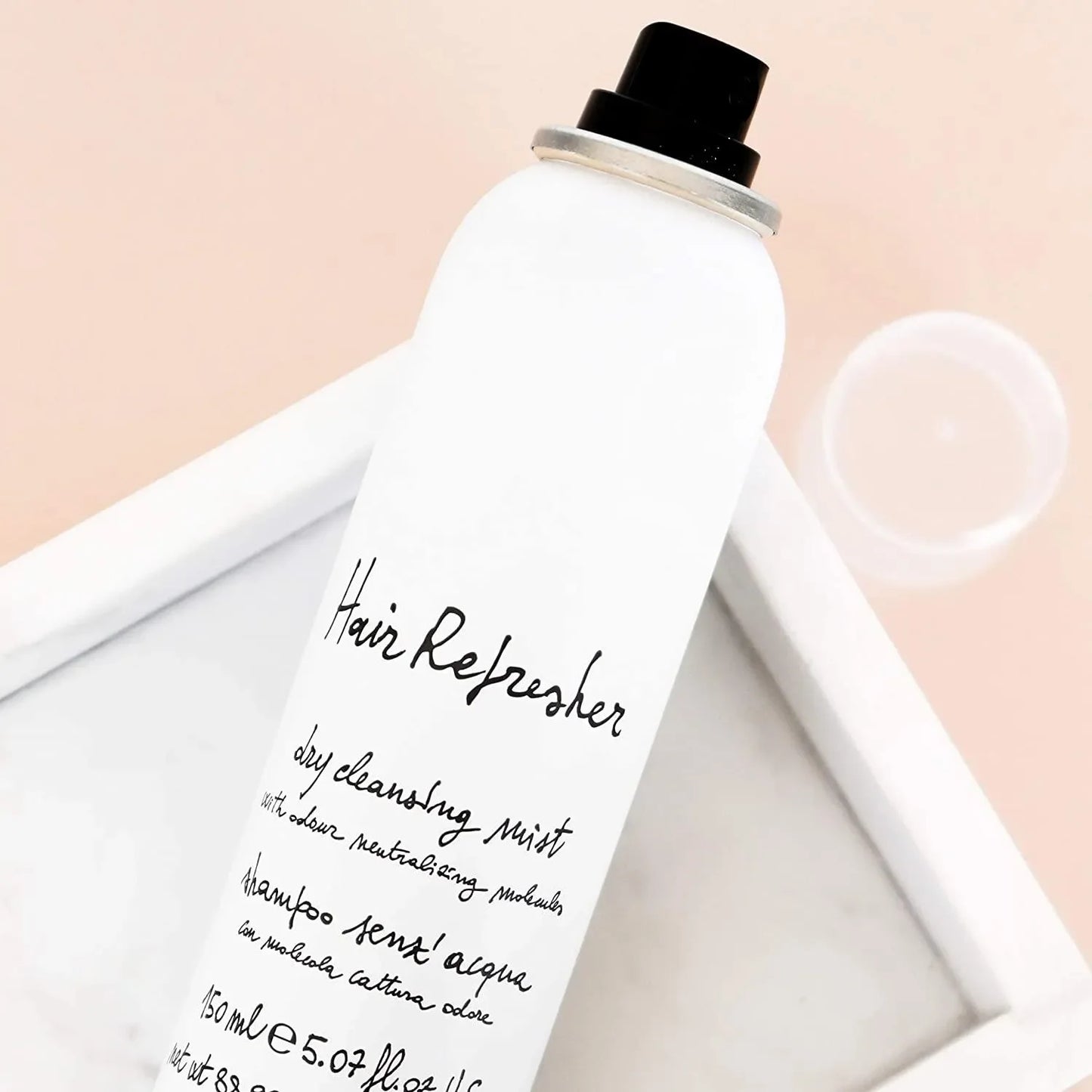 White hair refresher dry cleansing mist spray bottle for haircare on a marble tray