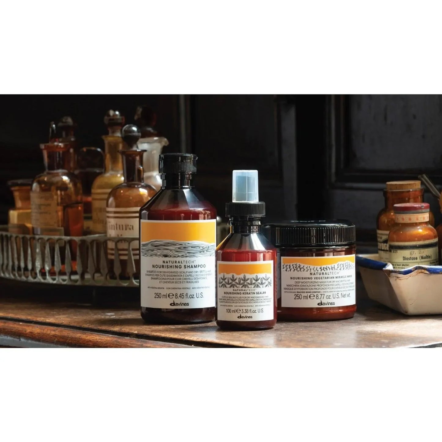 Davines nourishing keratin sealer and haircare bottles on a wooden counter, apothecary style