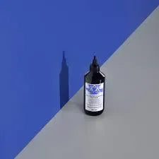 Davines Rebalancing Cleansing Treatment bottle on a gray and blue background for scalp care