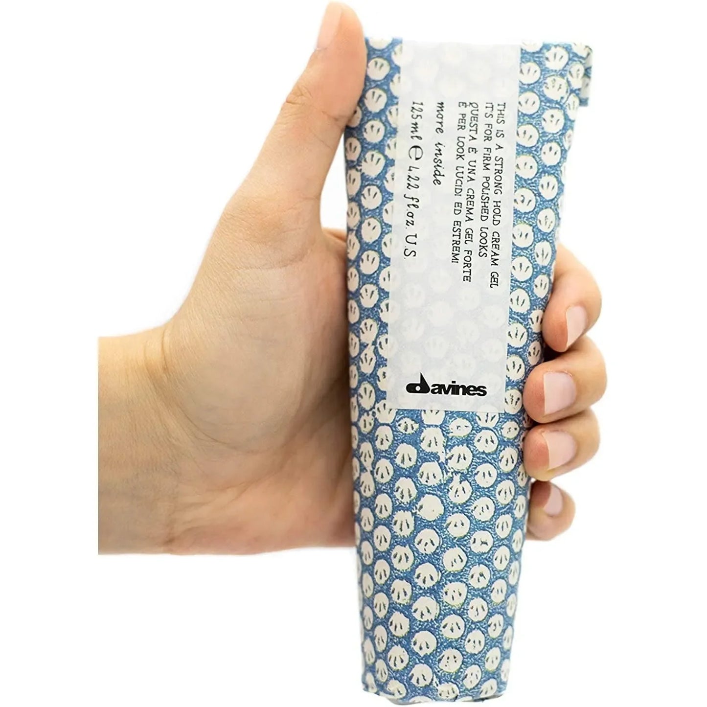 Hand holding Davines strong hold cream gel in blue patterned packaging, hair styling product