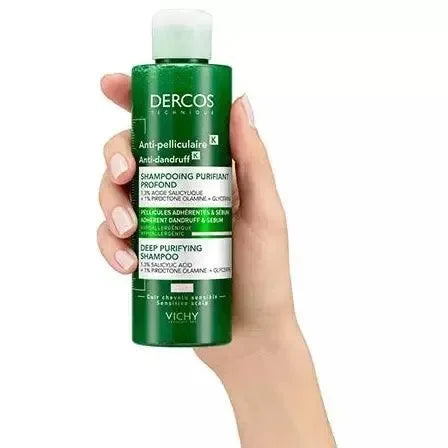 Hand holding Vichy Dercos Anti-Dandruff K purifying shampoo bottle, green packaging