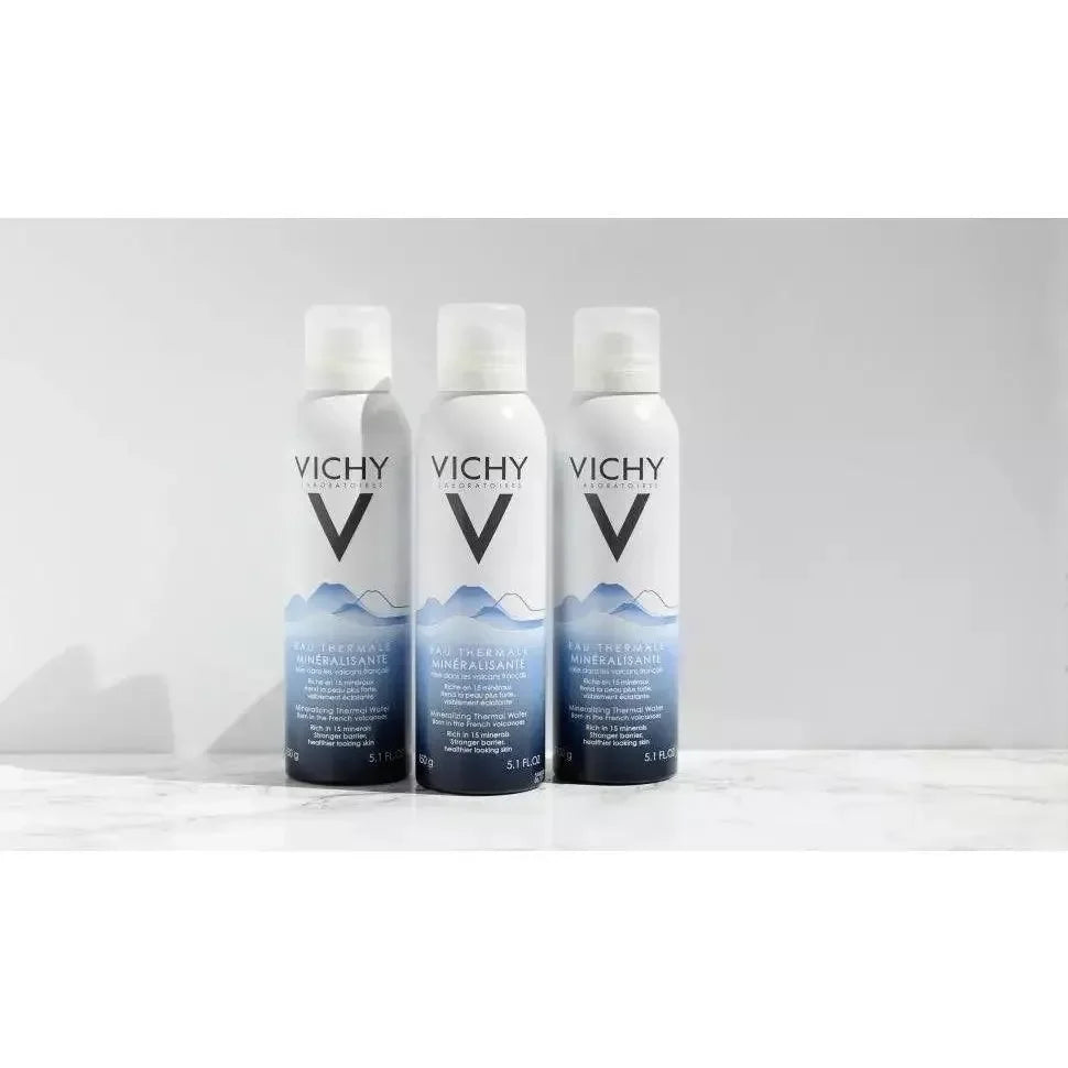 Three Vichy Mineralizing Thermal Water spray bottles for skincare on a white surface