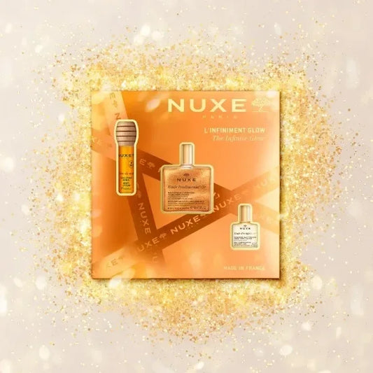 Nuxe The Infinite Glow Set skincare gift box with gold shimmer background at Goldfarmaci